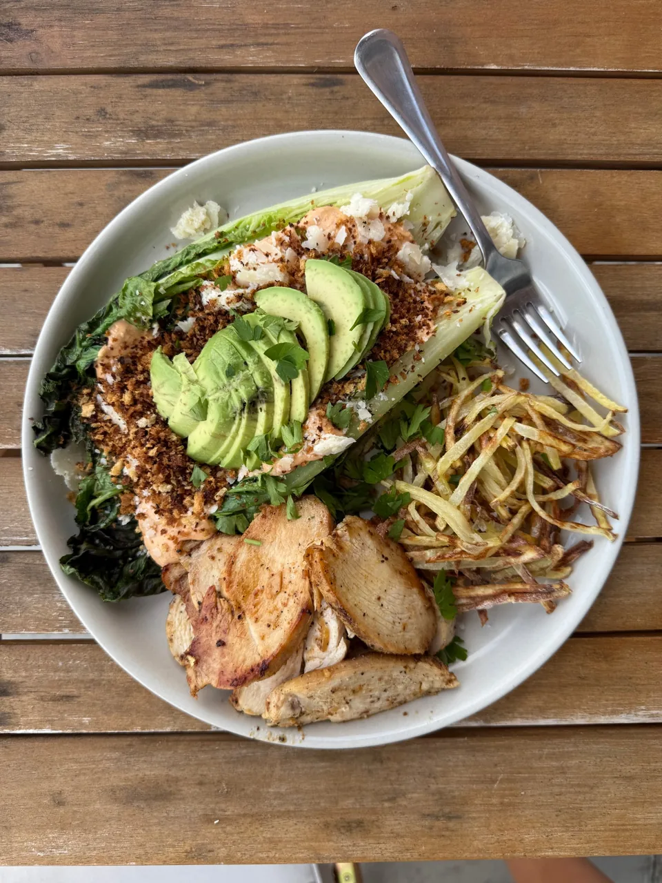 Grilled romaine with creamy dressing, toasted breadcrumbs, parmesan and avocado, with sliced chicken and shoestring potatoes