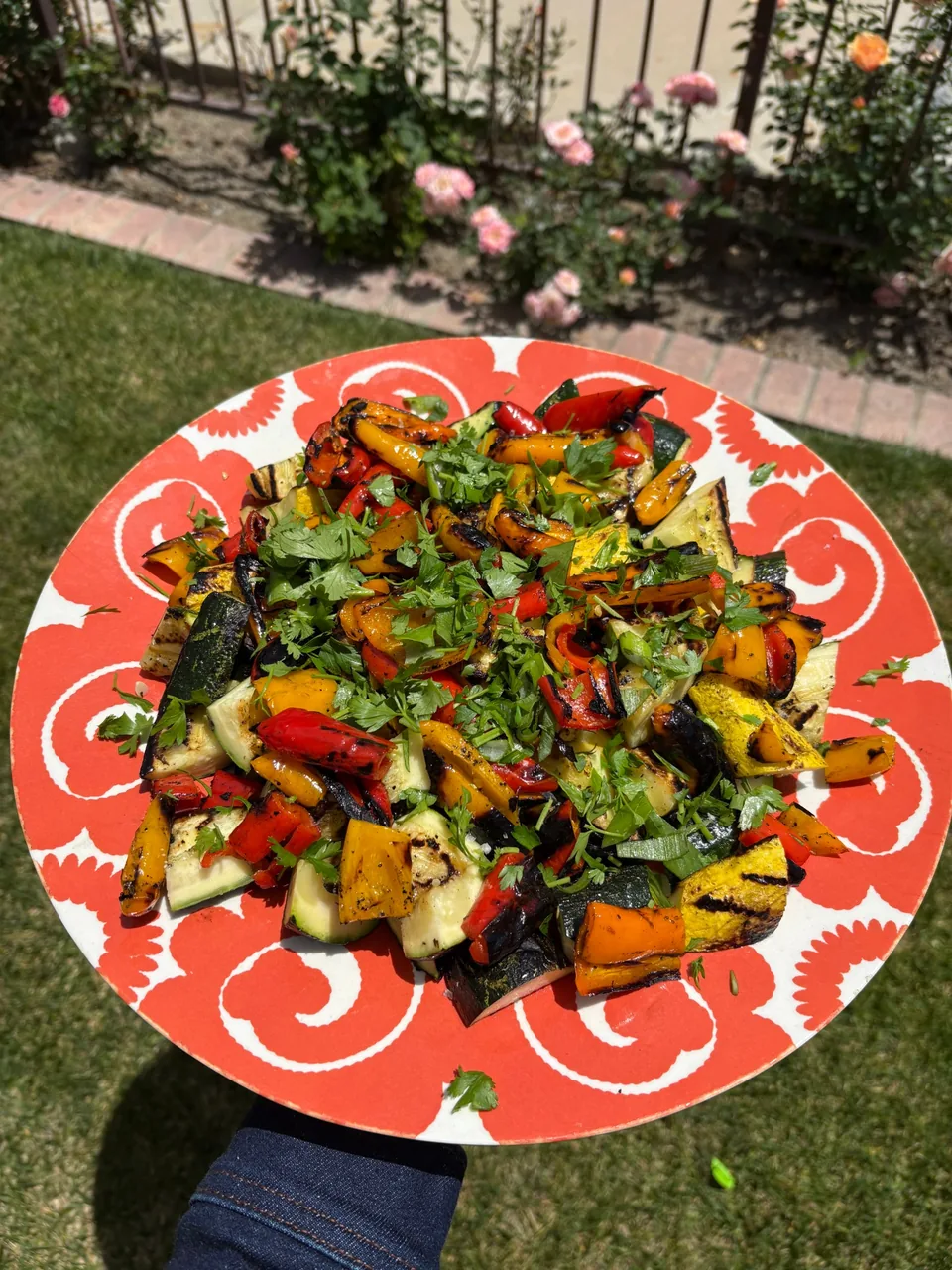 Platter of grilled sweet peppers, zucchini and yellow squash topped with parsley and scallions